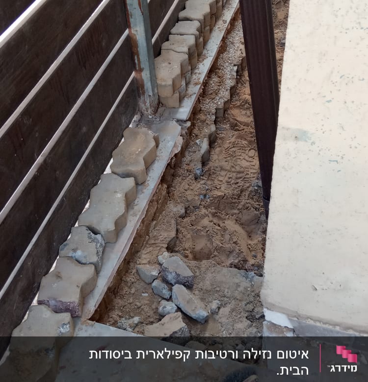 כלי עבודה וחול ליד גדר עץ